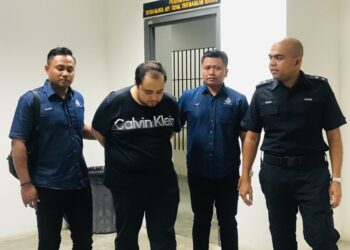 TERTUDUH Khairul Khuzaini Zamsani (dua dari kiri) diiring polis semasa hadir untuk prosiding perbicaraan di Mahkamah Sesyen Kota Bharu, Kelantan semalam. UTUSAN/ROSMIZAN RESDI