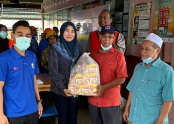 MOHD. HAFIZ Azmi (kiri) menyerahkan sumbangan bahan mentah di PPS Sekolah Jenis Kebangsaan (SJKT) Tamil di Kluang.