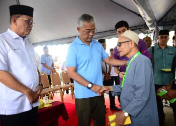 AL-SULTAN Abdullah Ri’ayatuddin Al-Mustafa Billah Shah (tengah) menyantuni dan menyampaikan sumbangan kepada mangsa banjir di Dewan Semai Bakti, Felda Chini 1 di Chini, Pekan, Pahang. - UTUSAN/SHAIKH AHMAD RAZIF