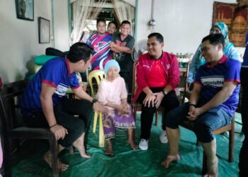 MUHAMAD AKMAL Saleh (dua dari kanan) beramah mesra dengan Bainah Ahmad semasa Misi Bantuan Banjir Pemuda UMNO di Kluang, Johor.