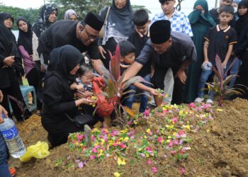 ANAK sulung Bella, Eusof menabur bunga atas pusara ibunya sambil kakak Bella, Norisham Shamsusah (kiri) memegang anak bongsu arwah, Maream yang menangis setelah selesai proses pengkebumian di Tanah Perkuburan Islam Taman Banang Jaya, Batu Pahat.