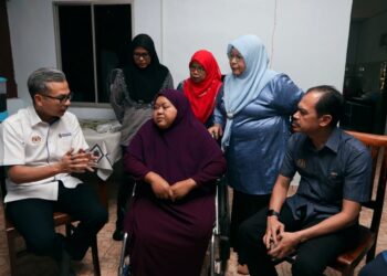 FAHMI Fadzil memperkatakan sesuatu kepada Norazlin Mohamad selepas menyampaikan sumbangan Tabung Kasih@HAWANA di Kampung Pulai, Serkam, Jasin, Melaka. - UTUSAN/AMRAN MULUP