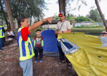 ANGGOTA penguat kuasa dari Majlis Perbandaran Port Dickson (MPPD) meminta pengunjung supaya tidak memasang khemah di Pantai Cahaya Negeri, Port Dickson baru-baru ini.-UTUSAN/MOHD. SHAHJEHAN MAAMIN.