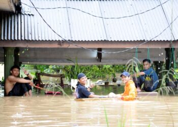 BEBERAPA penduduk berada di hadapan sebuah rumah yang dinaiki air di Kampung Paya Kenangan Desa Mutiara Johor Bahru , Johor.- UTUSAN/RAJA JAAFAR ALI