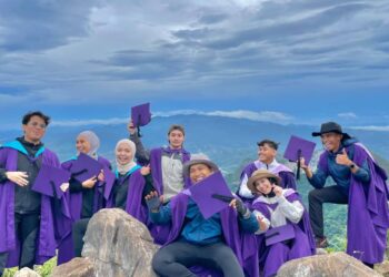 Muhammad Faizul Mohd Noor (kanan), Saleha Jasni (dua dari kanan) bersama rakan-rakannya mengabadikan kenangan mengayakan jubah preconvo di atas puncak Gunung Baling, baru-baru ini. - Norlia Ramli