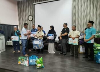 Mohd Na'im Mokhtar (depan, dua dari kiri) sedang menyampaikan bantuan makanan kepada mangsa banjir di Masjid Tengku Mahkota Abdullah, Jerantut, Pahang baru-baru ini.- UTUSAN/HARIS FADILAH AHMAD