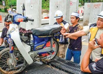 WARIS Haiqal Iman Mohd. Shahruddin Abdul Qayyum (tengah) membantu mengalihkan motosikal Allahyarham selepas kemalangan di Jalan Bukit Katil, Melaka. - UTUSAN/SYAFEEQ AHMAD