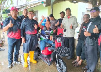 IBRAHIM Deris menerima sumbangan motosikal elektrik yang disampaikan Raja Shamri Raja Hussin di rumahnya di Kampung Banggol Setol, Pasir Mas, Kelantan hari ini.-UTUSAN/ROHANA ISMAIL