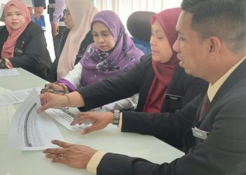 SAIRA (tengah) berbincang  bersama pegawainya di ibu pejabat JPV Pulau Pinang di Jalan Bukit Tengah, hari ini.