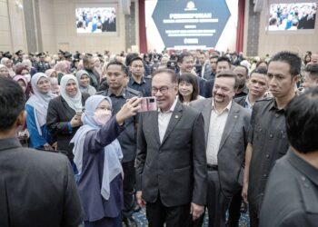 ANWAR Ibrahim beramah mesra dengan warga Kementerian Kewangan selepas majlis perhimpunan kementerian itu di Putrajaya, semalam. – utusan/FAIZ ALIF ZUBIR