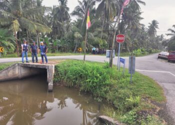 PENDUDUK menunjukkan parit di selekoh Jalan Tebuk Mufrad ke Jalan Haji Mat Yasin dan Jalan Parit Imun, Sabak Bernam, Selangor.