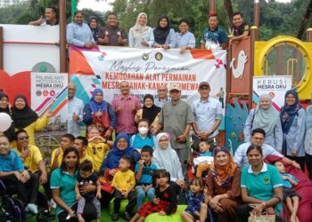 SYAMSUL Hazeman Md. Salleh (tengah) bergambar bersama kanak-kanak OKU dan keluarga mereka di taman permainan kanak-kanak istimewa di Marina Wing, Lumut, Perak. - UTUSAN/SHAMSUL KAMAL AMARUDIN