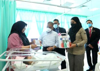 SAARANI Mohamad  (tengah) menyerahkan baucar Tabung Simpanan Anak Perak kepada seorang ibu yang melahirkan anak tahun baharu 2024 di Wad Bersalin HRPB di Ipoh. - UTUSAN/IHSAN YAYASAN PERAK