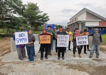 PENDUDUK dan peniaga mengadakan perhimpunan membantah cadangan pembukaan tapak pembuangan sampah di Batu 11, Lekir di Manjung. - UTUSAN/AIN SAFRE BIDIN