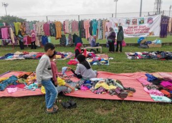 IBU bapa menjayakan jualan amal Tabika Perpaduan Taman Intan Mas di Taman Speedy di Teluk Intan, Perak. - UTUSAN/AIN SAFRE BIDIN