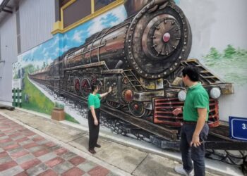 HOR Wai Home bersama isteri Lim Yar Ser melihat lukisan mural pada dinding kedai biskut yang mereka usahakan di Teluk Intan. – UTUSAN/AIN SAFRE BIDIN