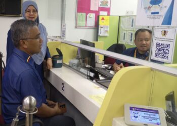 MASRI Razali meninjau keadaan kaunter baharu yang telah dinaik taraf selepas merasmikan Kaunter MBS Cawangan Nilai, hari ini.-UTUSAN/NUR SHARIEZA ISMAIL.