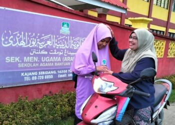 NOR Hayati CHe Ngah (kanan) memberikan restu kepada anaknya pada hari pertama peperiksaan SPM di SMU(A) Nurul Huda Kajang Sebidang Pengkalan Kubor, Tumpat, Kelantan-UTUSAN/ROHANA ISMAIL