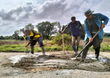 PENDUDUK kampung bergotong-royong menampal jalan yang berlubang di  laluan Kuala Jambu-Teluk Jering di Pengkalan Kubor, Tumpat, Kelantan hari ini-UTUSAN/ROHANA ISMAIL.