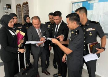 MOHD. Sophian Zakaria (tiga dari kiri), Suhana Mohd (kiri) dan Shafiq (tiga dari kanan) berbincang dengan pegawai KPDN selepas prosiding pendakwaan kedua-dua OKS di Mahkamah Majistret Kota Bharu, Kelantan hari ini.