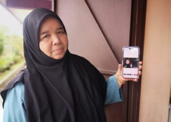 IBU mangsa, Jamaliah Dahlan, 58, menunjukkan gambar Nurhafizah yang kini koma dan dirawat di ICU HTJS, Seremban.