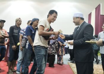 MOHD. Nassuruddin Daud (kanan) menyampaikan Bantuan Banjir Sumbangan Yayasan Sultan Kelantan Peringkat Jajahan Pasir Mas di Dewan Apam Putra, Pasir Mas, Kelantan hari ini-UTUSAN/ROHANA ISMAIL.