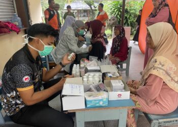 SEORANG mangsa banjir (kanan) menjalani pemeriksaan di kesihatan selepas berlindung di pusat pemindahan sementara (PPS) SK Canggai, Pasir Puteh, Kelantan-UTUSAN/TOREK SULONG.