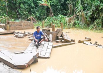 SEORANG penduduk sayu melihat keadaan rumahnya yang dihanyutkan arus deras dalam kejadian banjir besar di Kampung Shukor, Hulu Dungun, Terengganu, semalam. - UTUSAN/PUQTRA HAIRRY ROSLI