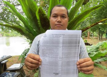 DENDI Johari menunjukkan salinan laporan polis yang dibuat di Ibu Pejabat Polis Daerah Gua Musang. FOTO: AIMUNI TUAN LAH