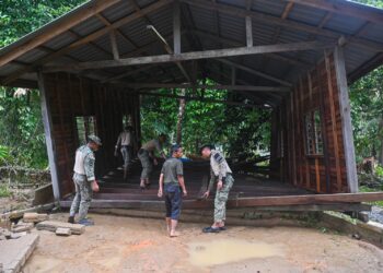 ANGGOTA Angkatan Tentera Malaysia meninjau keadaan salah sebuah rumah penduduk yang runtuh dalam kejadian banjir  di Kampung Shukor, Hulu Dungun, hari ini. - UTUSAN/NIK NUR IZZATUL HAZWANI NIK ADNAN