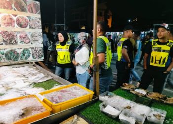 ANGGOTA penguatkuasa melakukan pemeriksaan mengejut di premis makanan sekitar Pantai Teluk Nipah, Pulau Pangkor. - UTUSAN/IHSAN KPDN PERAK