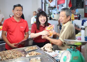 LIM Hui Ying (tengah) ketika sesi 'walkabout' untuk mengagihkan sampul angpau dan limau Mandarin di Pasar Chowrasta sempena sambutan Tahun Baharu Cina. - UTUSAN/IQBAL HAMDAN