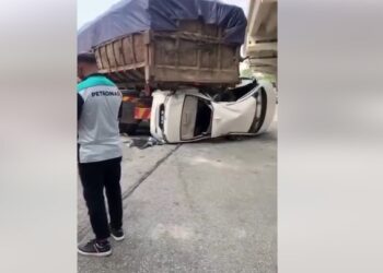 KERETA Honda City terperosok ke bawah lori selepas dirempuh.