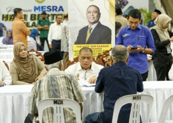 SAARANI Mohamad (tengah) meneliti aduan rakyat pada program Hari Bertemu Pelanggan di Stadium Indera Mulia di Ipoh hari ini. - UTUSAN/MUHAMAD NAZREEN SYAH MUSTHAFA