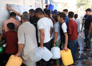 RAKYAT Palestin beratur untuk mengisi bekas dengan air di Khan Younis di selatan Gaza. -AFP