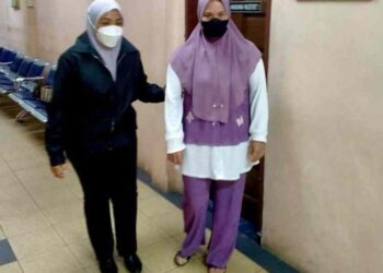 TERTUDUH (kanan) semasa dibawa keluar dari Mahkamah Khas Rasuah, Tawau hari ini