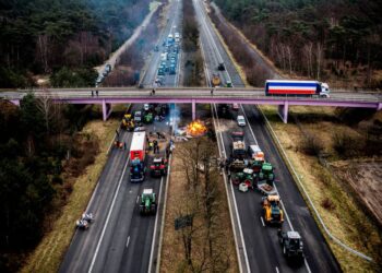 GAMBAR pemandangan udara menunjukkan petani menyekat jalan raya di Arendonk, berhampiran sempadan antara Belgium dan Belanda. - AFP