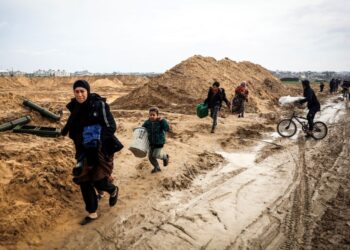 PENDUDUK Gaza berjalan kaki membawa barangan mereka keluar dari bandar Khan Yunis.-AFP