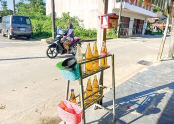 MINYAK petrol seludup dari Malaysia di tepi jalan di kebanyakan kawasan di Sukhirin, Narathiwat, Thailand. - UTUSAN/AIMUNI TUAN LAH