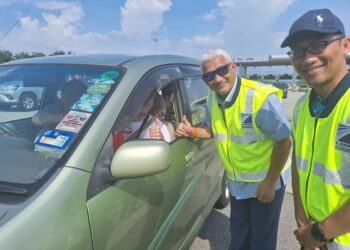 AHMAD FUAD (beruban) beramah mesra dengan pengguna lebuhraya itu di di Plaza Tol Ijok, LATAR, Kuala Selangor, Selangor petang ini.-FOTO/ ISKANDAR SHAH MOHAMED