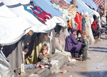 SEORANG wanita dan kanak-kanak duduk di luar khemah pelarian Palestin di Rafah, selatan Gaza.-AFP