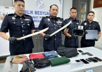 AHMAD Zamry Marinsah (dua dari kiri) menunjukkan parang dan barang bukti yang digunakan suspek Geng Parang di IPD Segamat