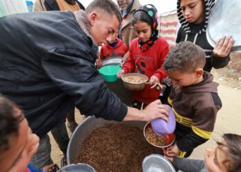 KANAK-kanak Palestin menerima makanan yang dimasak oleh badan sukarela dapur amal di Rafah, selatan Gaza. -AFP