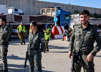 PENGAWAL sempadan Israel berkawal berhampiran trak Mesir yang membawa masuk bekalan bantuan kemanusiaan ke Gaza, di sebelah Israel lintasan sempadan Kerem Shalom dengan wilayah Palestin. -AFP