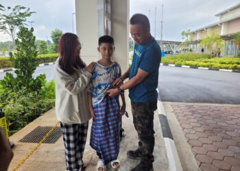 KOH Min Zhe (tengah) diberikan kata-kata semangat oleh bapanya, Koh Eyo Lee (kanan) dan kakaknya, Koh Pei Yee, 20 (kiri) untuk menjalani berkhatan di Hospital Tanah Merah semalam. – UTUSAN/MUSTAQIM MOHAMED