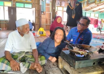 MOHAMAD Ab. Kadir  tidak kekok memasak sambil ditemani ayahnya, Ab. Kadir (kiri) ketika dikunjungi Raja Shamri Raja Hussin di rumahnya di Kampung Banggol Ubi Keling, Pasir Mas, Kelantan.-UTUSAN/ROHANA ISMAIL.