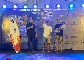 Mohd. Shahar Abdullah (kiri) dan Ahmad Shahrimie Abdul Muin (kanan) menyampaikan hadiah kepada peserta dari Indonesia yang menjuarai acara Longboard Lelaki. UTUSAN/NORHAFIZAN ZULKIFLI