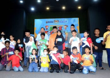 Suhaizan Kaiat (baju oren) bersama murid-murid sekolah yang menerima baucar  Yayasan Bank Rakyat sempena Program Kembali Ke sekolah @B2S Parlimen Pulai di Dewan Hassan Abdullah, Kampung Pasir Tampoi, Johor Bahru hari ini. UTUSAN/RAJA JAAFAR ALI