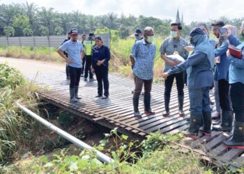 FAHMI Zainol (tengah) diberi penerangan mengenai isu pelepasan sisa babi ke Sungai Kulim, Kedah ketika melawat ladang ternakan haiwan itu di Sungai Lembu, Bukit Mertajam, Pulau Pinang semalam.