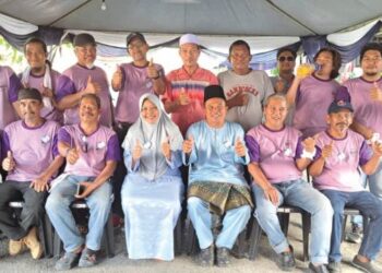 SEBAHAGIAN daripada penduduk Taman Ros berfoto bersama Hamsan Tumardi dan isterinya (tengah), selepas majlis perkahwinan. – FOTO/MUSTAFFA SIRAJ